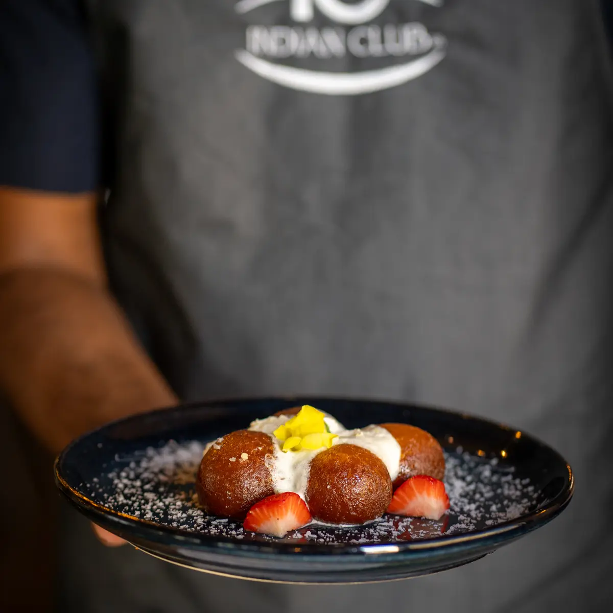 Server presenting desert dish.