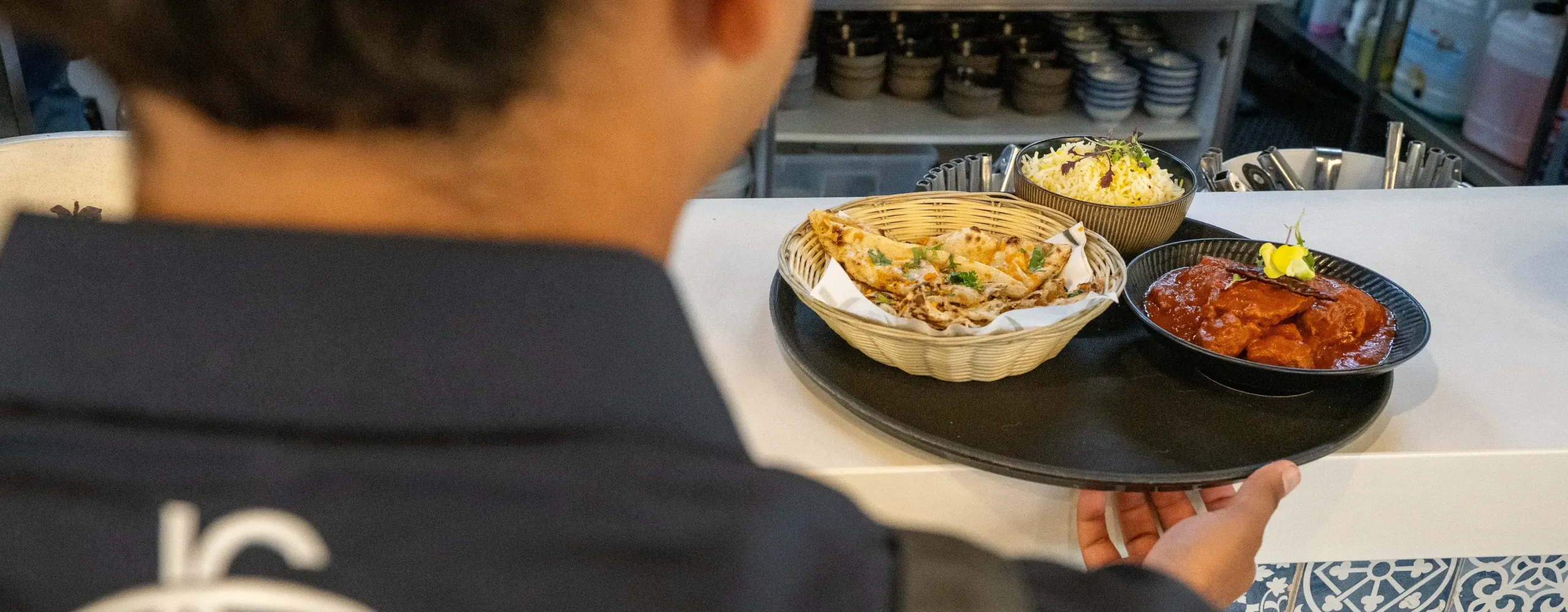Waiter getting food from kitchen counter.