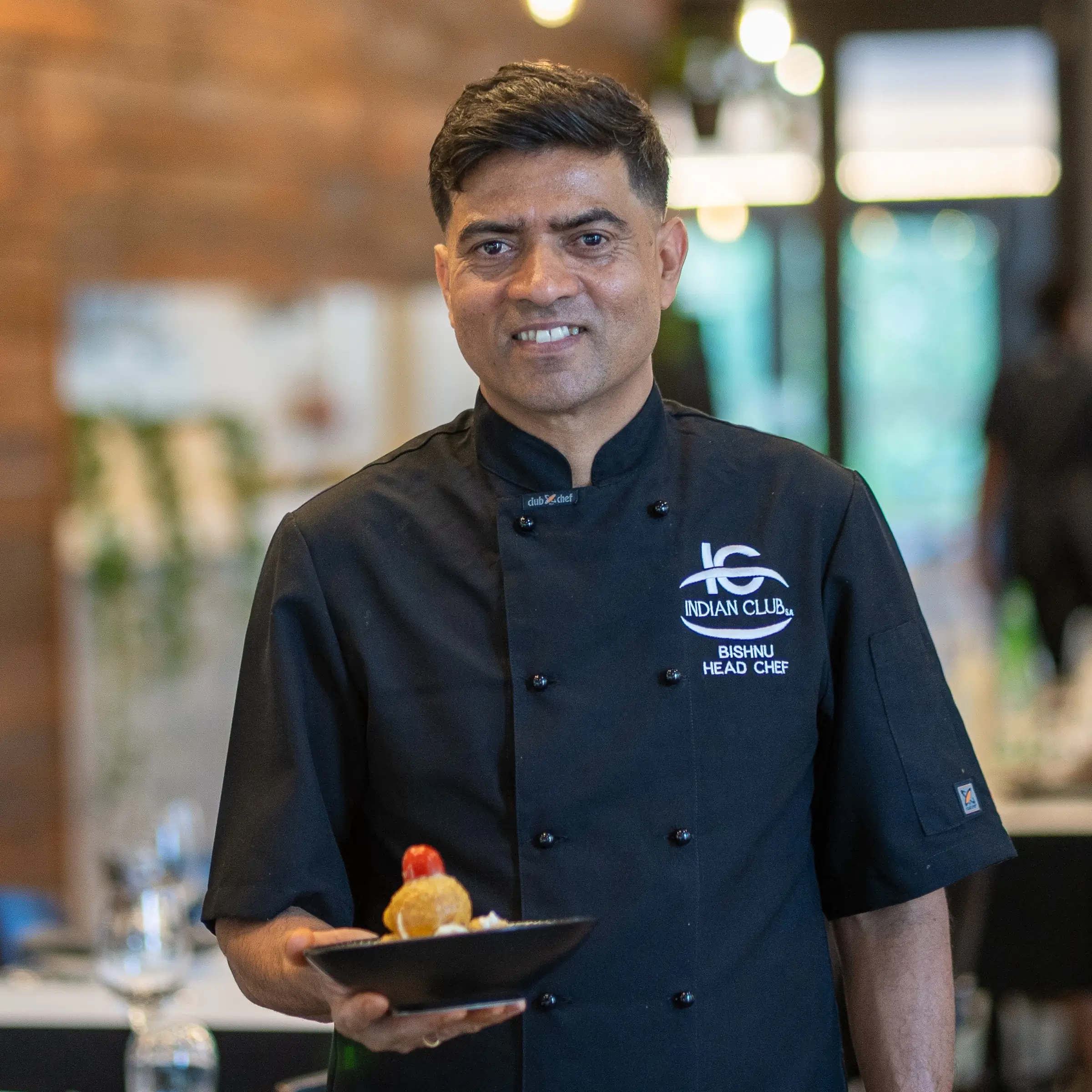 Headshot of Bishnu Kharel with plate of food.